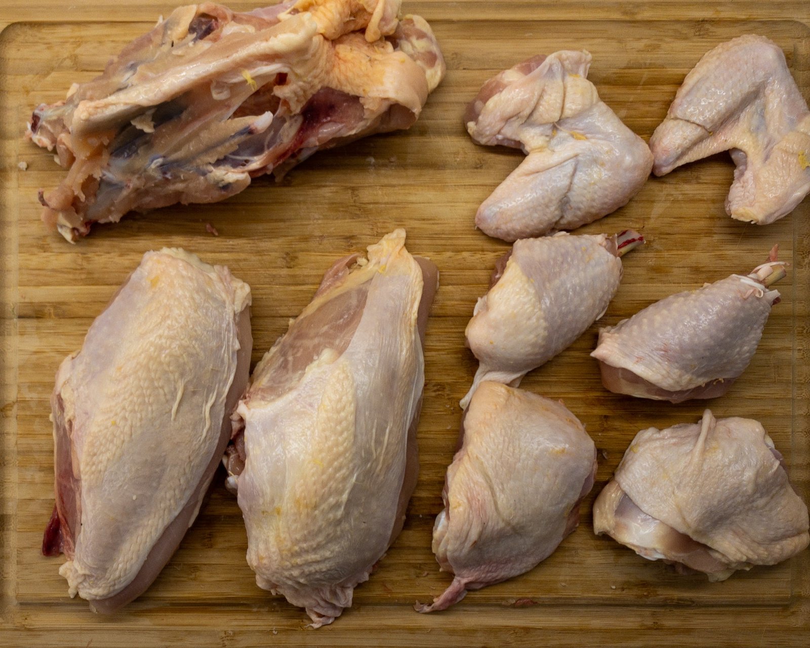 A jointed chicken layer out on a chopping board