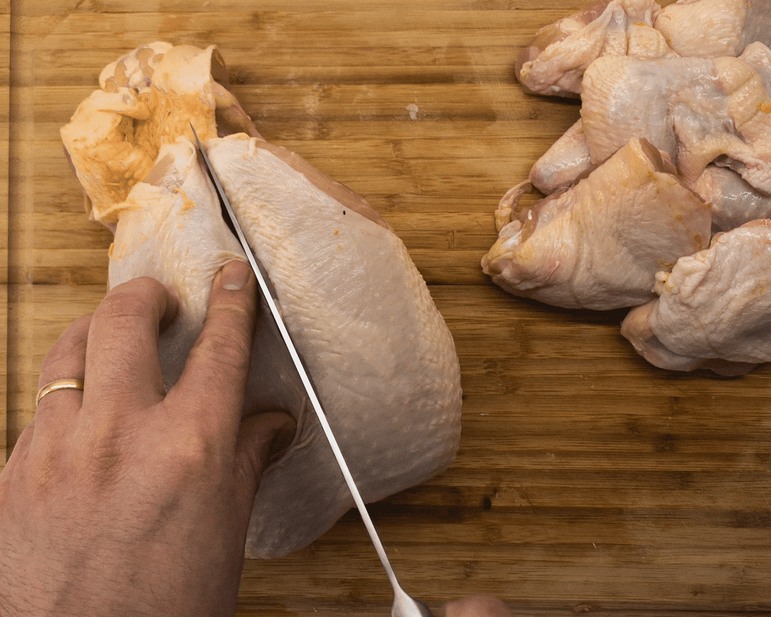 Slicing down the breastbone of a chicken to remove a chicken breast