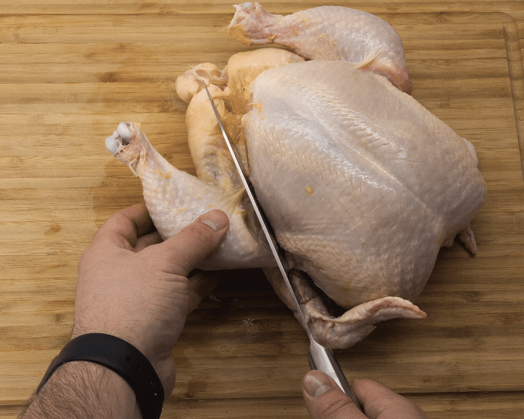 Cutting the leg off a chicken