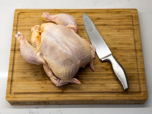 Raw chicken and knife on a chopping board