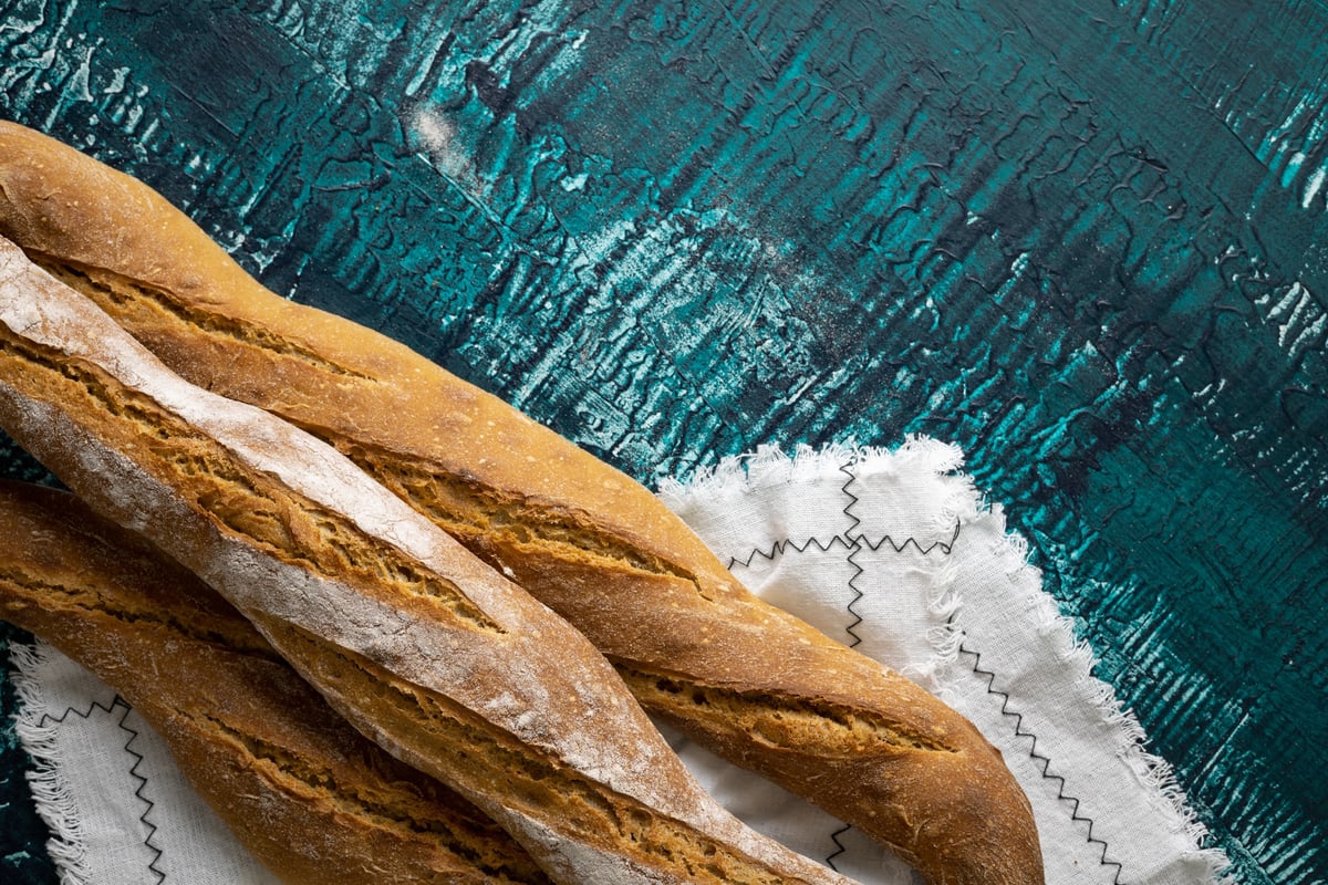 Three artisan sourdough demi-baguettes with diagonal scoring