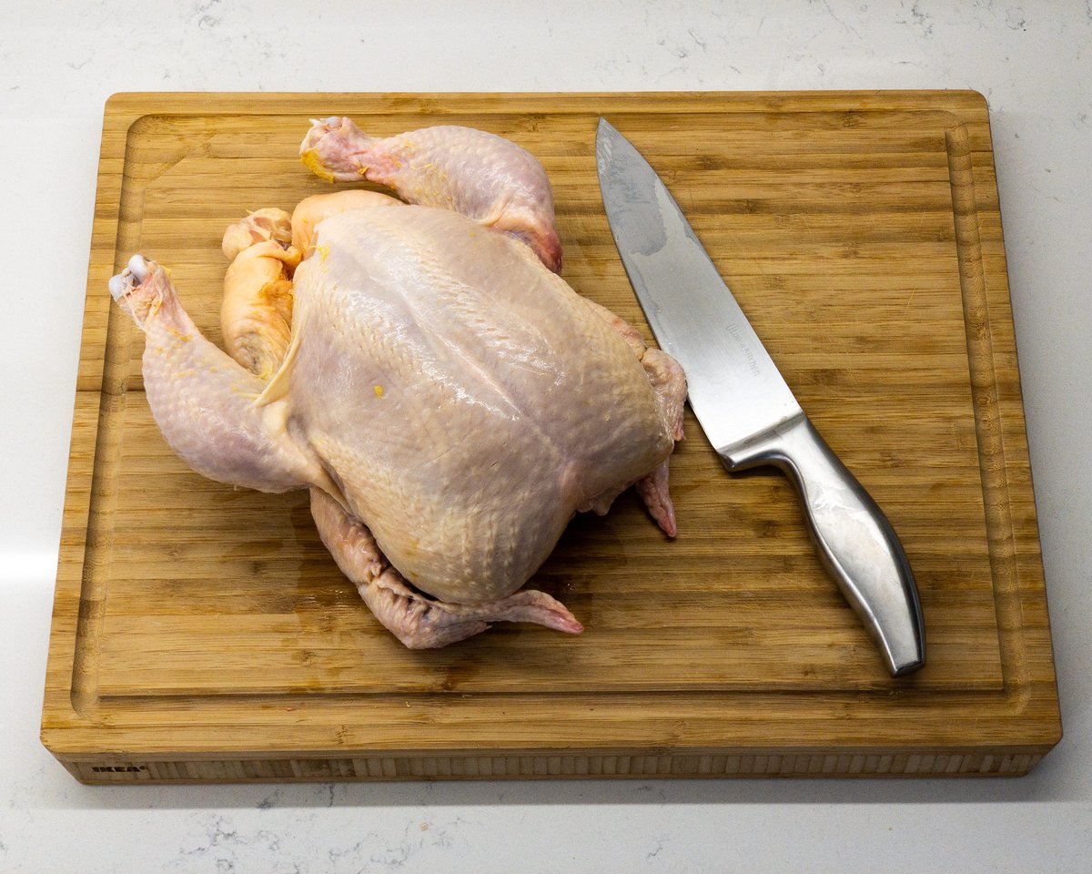 Raw chicken and knife on a chopping board