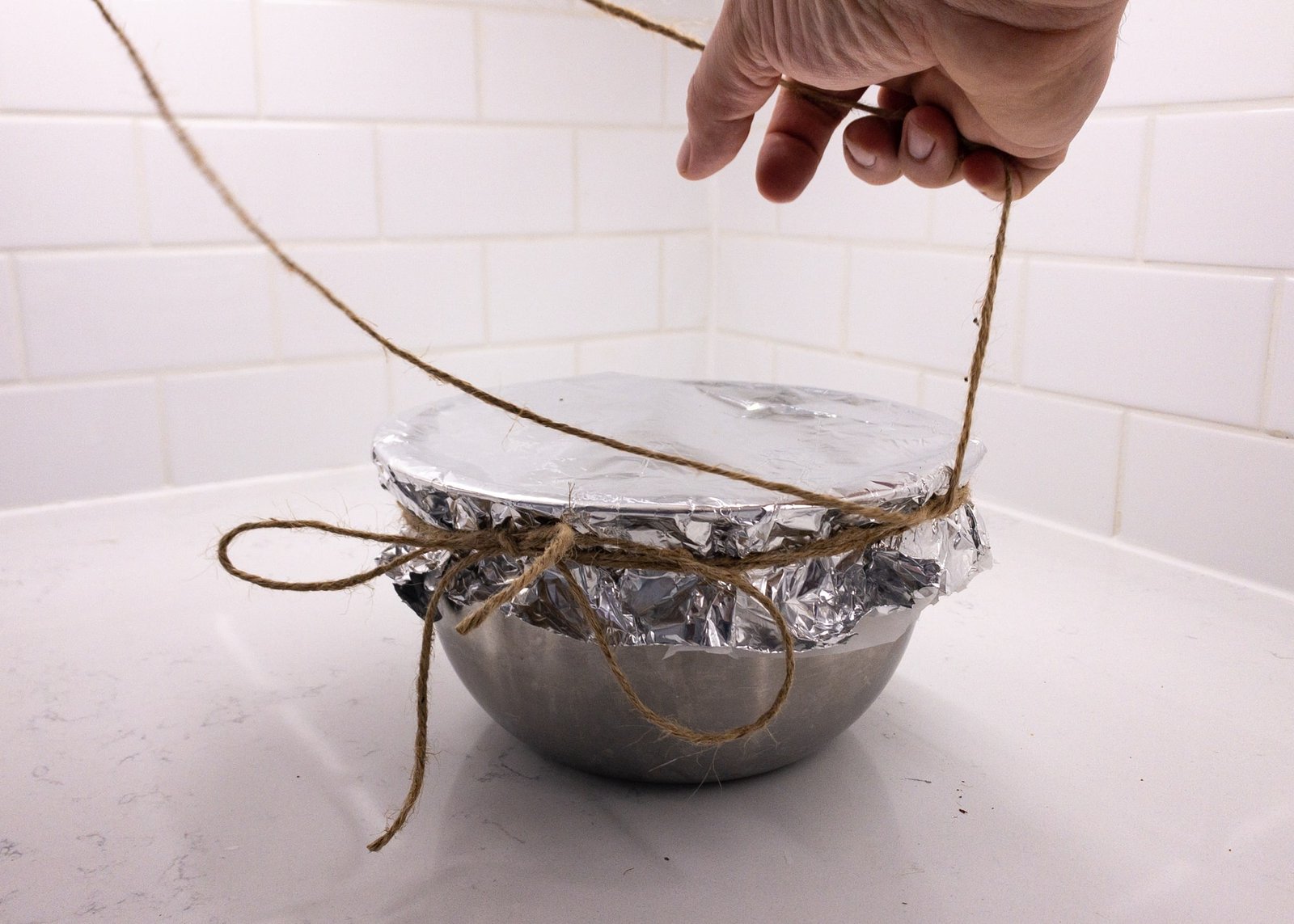 Bowl with foil top secured by string with string handle