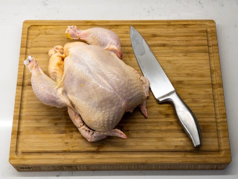 Raw chicken and knife on a chopping board